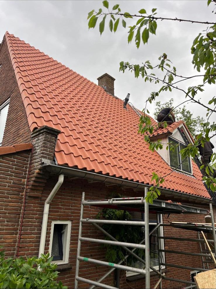 Nieuw oranje pannendak met dakkapel tijdens de oplevering