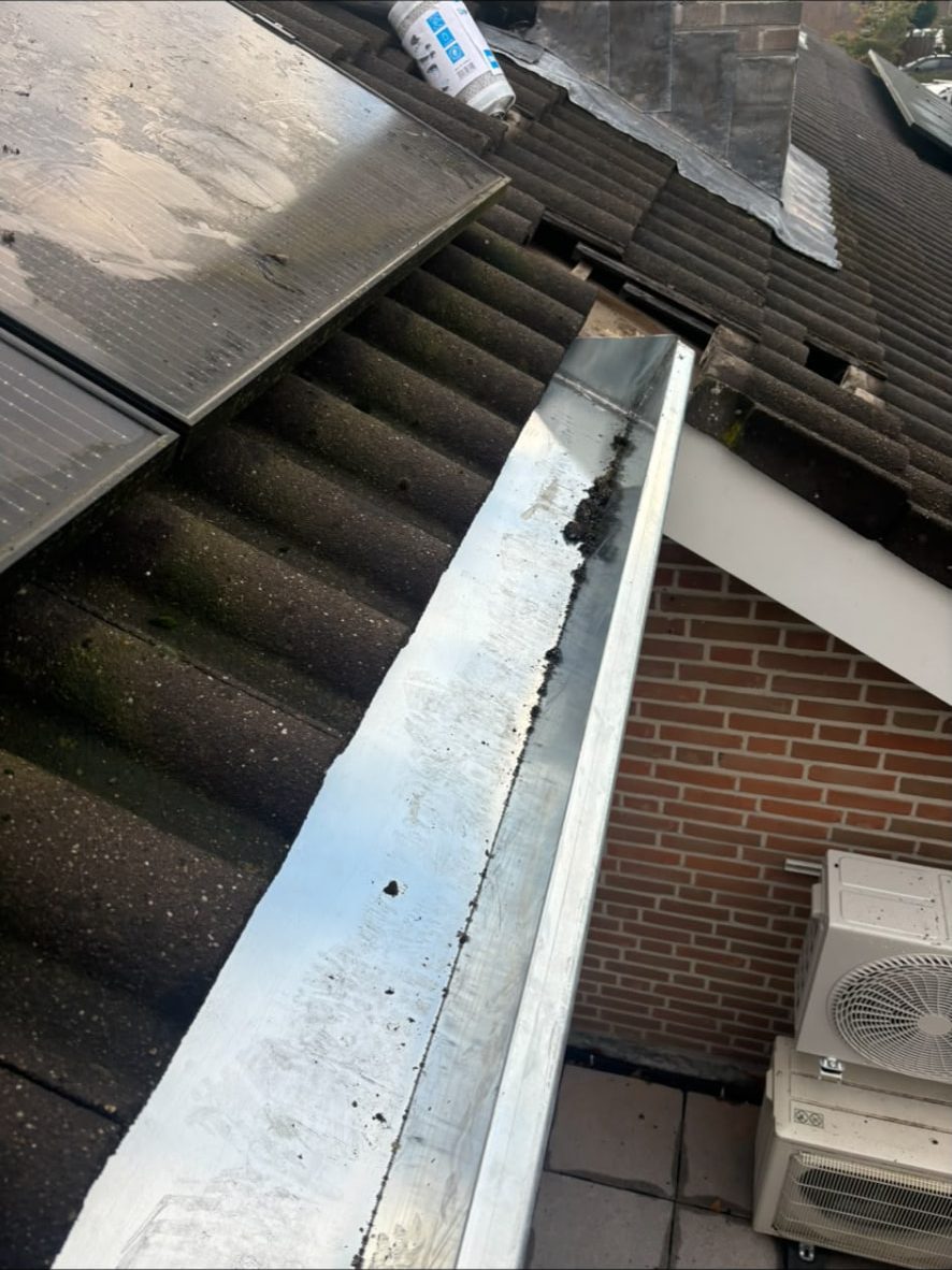 Nieuw zinken goot- en zinkwerk langs de dakrand van een aanbouw