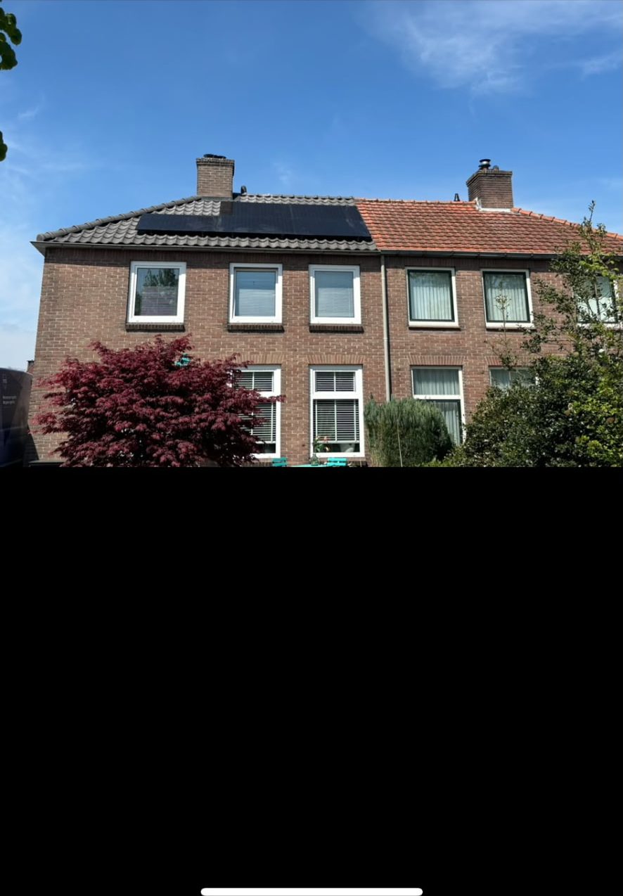 Woning met vernieuwd pannendak en zonnepanelen naast het oude dak