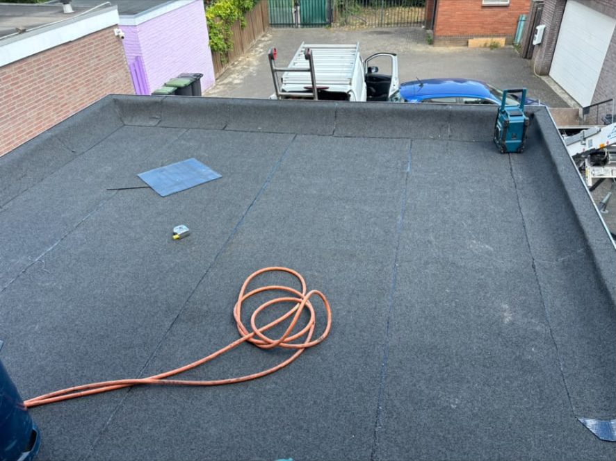 Strak afgewerkt plat dak met nieuwe bitumen dakbedekking en dakrand