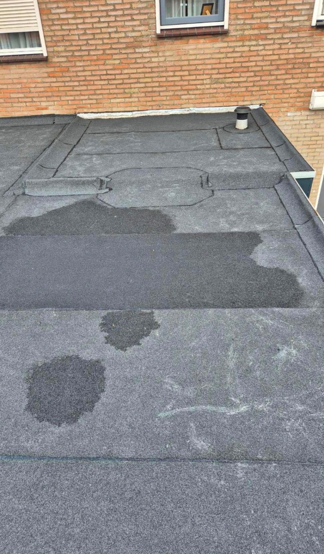 Plat dak met bitumen dakbedekking en lokale reparatieplekken