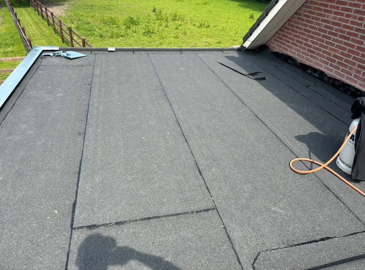 Plat dak van een aanbouw met nieuwe bitumen dakbedekking