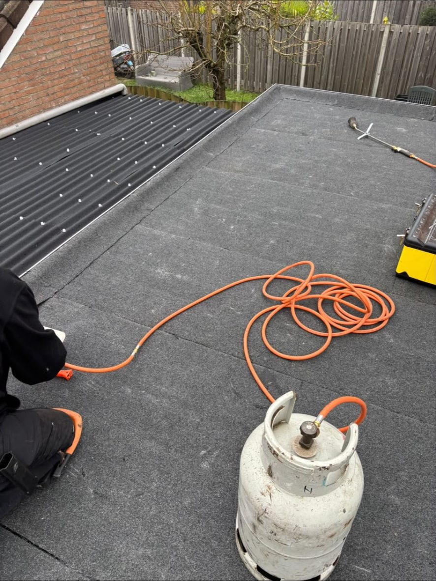 Bitumen dakbedekking dichtbranden op een plat dak met gasfles