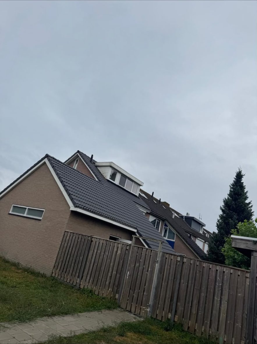 Woning met vernieuwd antraciet pannendak en dakkapel