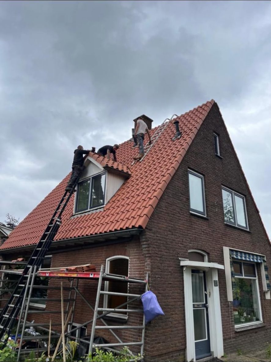 Dakdekkers vervangen het pannendak van een woning met dakkapel